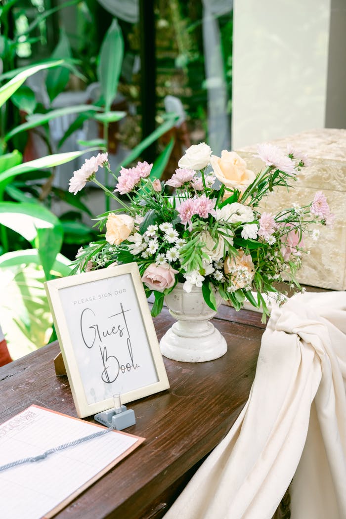 Charming floral arrangement and guest book setup in a bright, rustic setting, ideal for weddings.